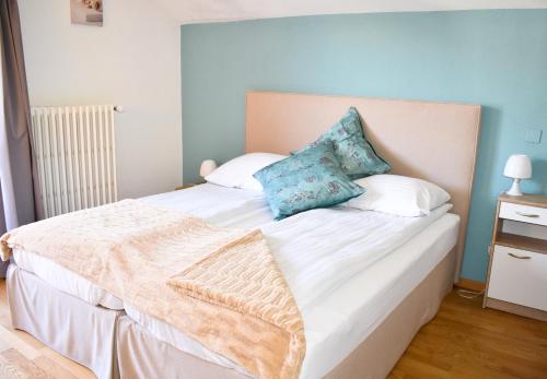 a bedroom with a large white bed with blue walls at Hostellerie d'Orzival in Vercorin