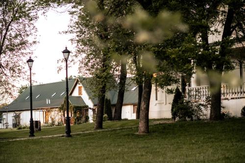 una casa blanca con dos luces de la calle en el césped en Dwór Mościbrody, en Siedlce