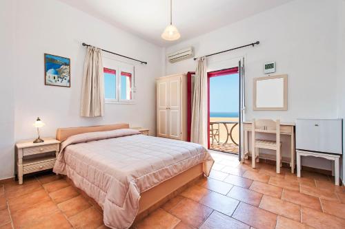 a bedroom with a bed and a desk and a window at Pension The Flower in Oia