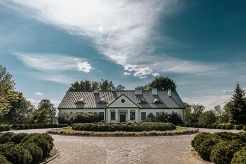 uma casa com um telhado cinzento e uma entrada em Dwór Mościbrody em Siedlce