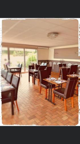 uma sala de jantar com mesas e cadeiras em Hôtel le Bretagne et Restaurant Le Papillon em Gorron