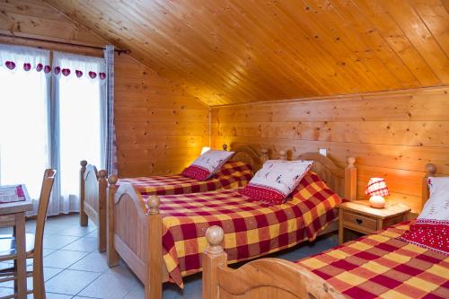 a bedroom with two beds in a wooden cabin at CHAMBRE d'HÔTE LA PETITE BERGERIE in La Chapelle-dʼAbondance