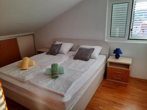 a large white bed with two stuffed animals on it at Apartman Martina in Rab