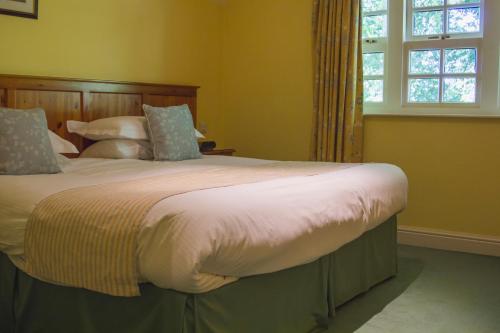 a large bed in a bedroom with a window at Briery Wood Hotel in Ambleside