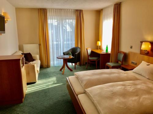 um quarto de hotel com uma cama, uma cadeira e uma secretária em Hotel Haus Deckers em Geldern