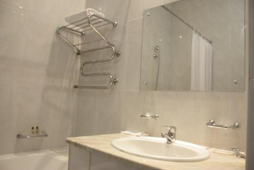 a bathroom with a sink and a mirror and a tub at Astoria Lux in Dnipro
