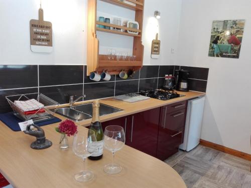 a kitchen with two wine glasses on a table at Les Rosiers in Chaunay