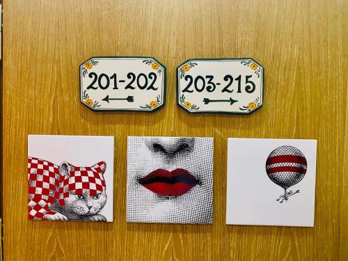 four signs with pictures of a cat and a balloon at Hotel Il Guercino in Bologna