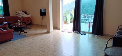 a living room with a large glass door to a balcony at DoiTung Homestay ดอยตุงโฮมสเตย์ in Chiang Rai