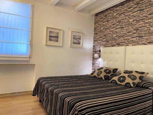 a bedroom with a bed and a brick wall at Hotel Il Guercino in Bologna