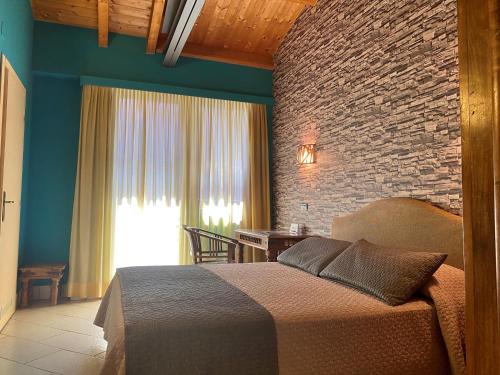 a bedroom with a bed and a brick wall at Hotel Il Guercino in Bologna