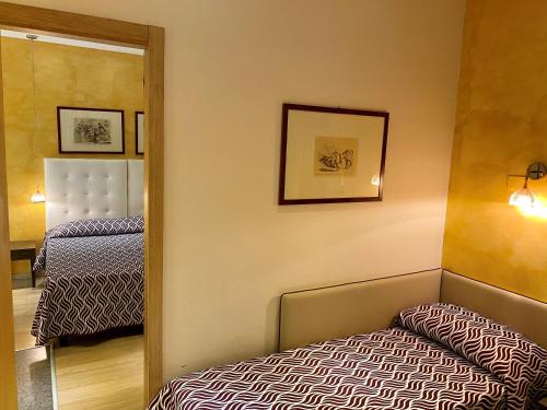 a small room with a bed and a mirror at Hotel Il Guercino in Bologna