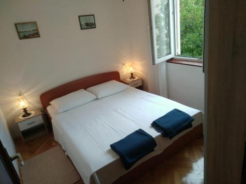 ein Schlafzimmer mit einem Bett mit zwei blauen Kissen darauf in der Unterkunft Apartments Meri in Dramalj