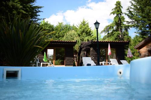 a swimming pool with chairs and a house at Quinta Sul America in Moimenta da Beira