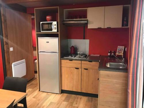 a small kitchen with a refrigerator and a sink at PetraLegna in Porto-Vecchio