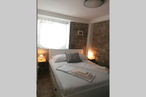 ein kleines Schlafzimmer mit einem Bett und einem Fenster in der Unterkunft Rovinj Home with a Garden by Rocco in Rovinj