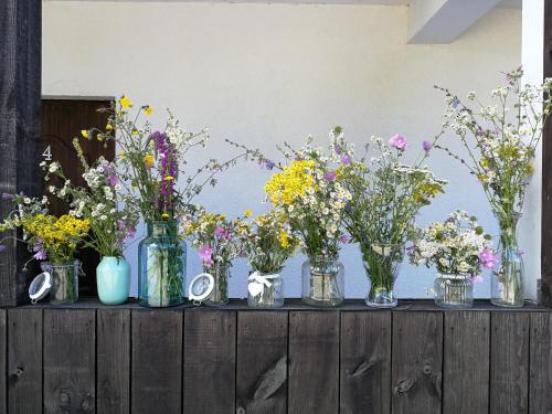 a group of vases filled with flowers on a table at Niebieska Tawerna in Węgorzewo