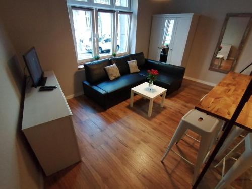 een woonkamer met een zwarte bank en een tafel bij Studio Krakow old town apartment in Krakau