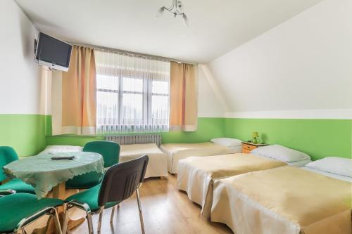 ポロニンにあるDom Wczasowy Jesionkówkaのベッド2台、テーブル、椅子が備わる客室です。