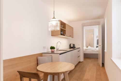 a kitchen and dining room with a table and a sink at Kuntino Suites in Merano