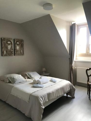 a bedroom with a bed with white sheets and a window at Auberge de la fontaine aux loups in Saint-Sulpice-le-Dunois