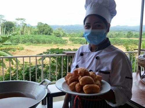 a chef wearing a mask holding a plate of food at Nakakiri Resort & Spa in Hin Dat