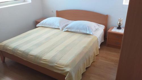 um quarto com uma cama com duas almofadas e uma mesa de cabeceira em Lastovo City Center em Lastovo