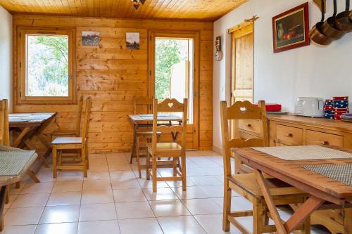 un comedor con mesas y sillas en una cabaña en CHAMBRE d'HÔTE LA PETITE BERGERIE, en La Chapelle-dʼAbondance