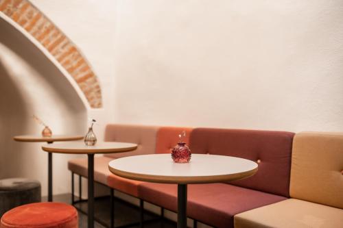 a room with a couch and two tables at Kuntino Suites in Merano