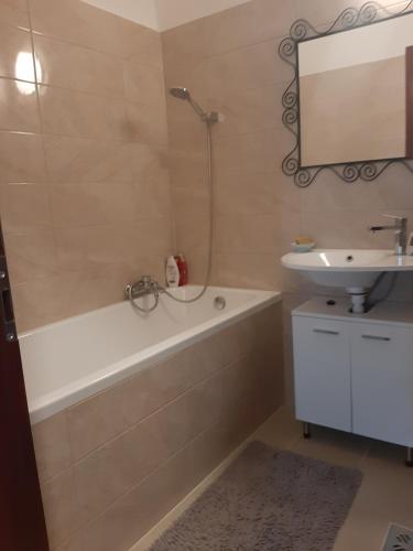 a bathroom with a bath tub and a sink at Megyeri Apartman in Pócsmegyer