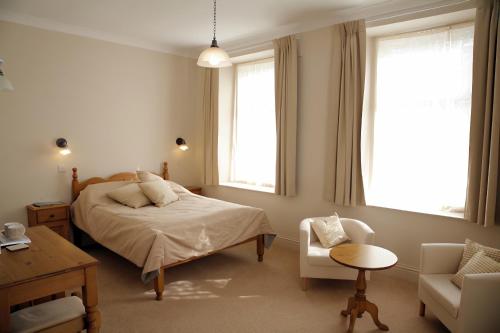 1 dormitorio con 1 cama, 1 silla y 1 mesa en The Reading Rooms en Haydon Bridge