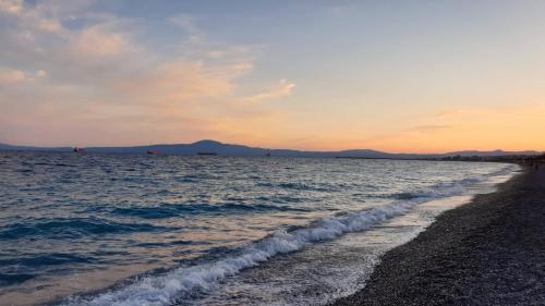 a beach with the ocean and the sunset in the background at Vista Marina in Kalamata