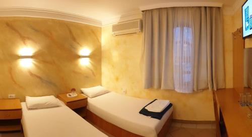 a hotel room with two beds and a window at ESTRADA Lux in Belgrade