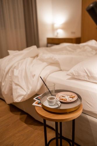a tray of food on a table next to a bed at Kuntino Suites in Merano