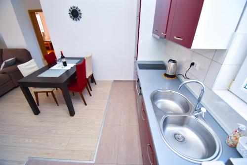 eine kleine Küche mit einem Waschbecken und einem Tisch in der Unterkunft Apartment ViP in Zadar