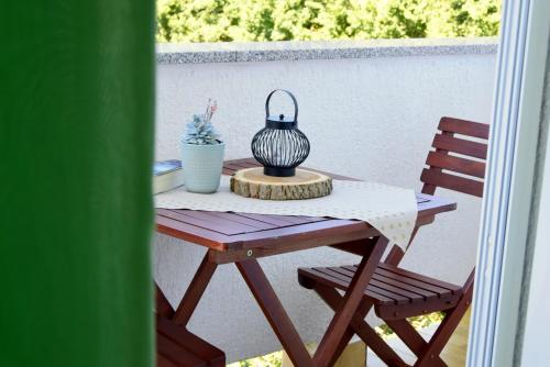 einen Tisch mit einer Vase und zwei Stühlen auf einer Terrasse in der Unterkunft James Bond Apartments in Rab
