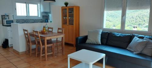 sala de estar con sofá azul y mesa en Apartamento muy tranquilo con piscina, en Tossa de Mar
