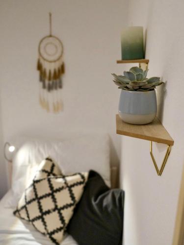 a room with a bed and a plant on a shelf at Apartment Danielsbergblick in Napplach