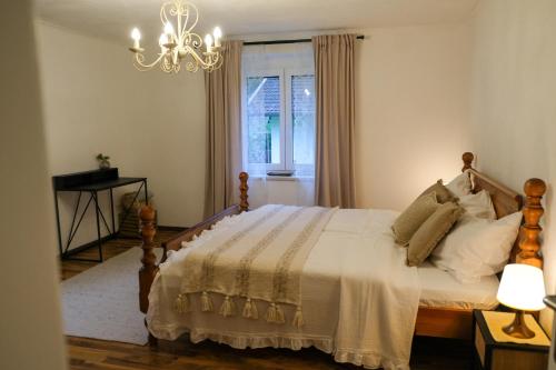 a bedroom with a bed with a chandelier and a window at Apartment Danielsbergblick in Napplach