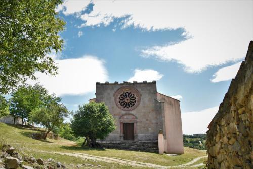 an old stone building with a tree in front of it at B&B I Menhir in Sorgono