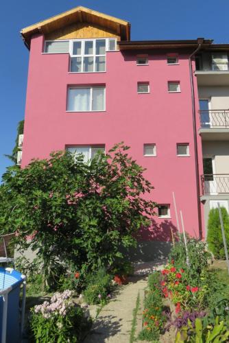 a pink building with flowers in front of it at Guest House 51 in Kranevo