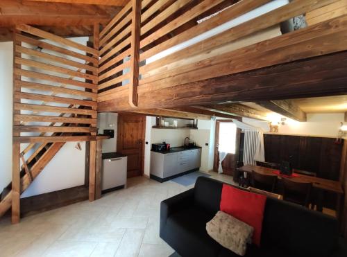 un soggiorno con divano nero e soffitti in legno di Chalet Saint Salod - Pila a Charvensod