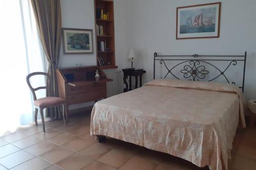 a bedroom with a bed and a desk and a chair at VelaLatina Residence B&B Soverato in Soverato Marina