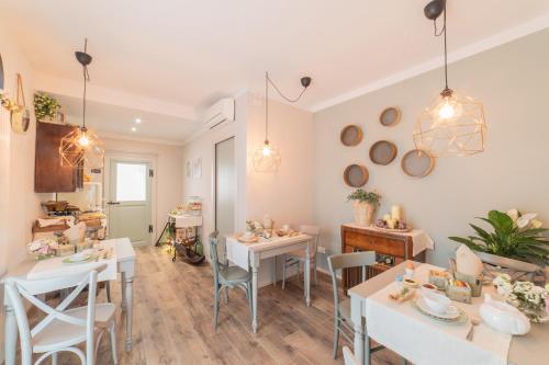 una sala da pranzo con tavoli e sedie bianchi di La Dimora del Mugnaio a San Giovanni in Marignano