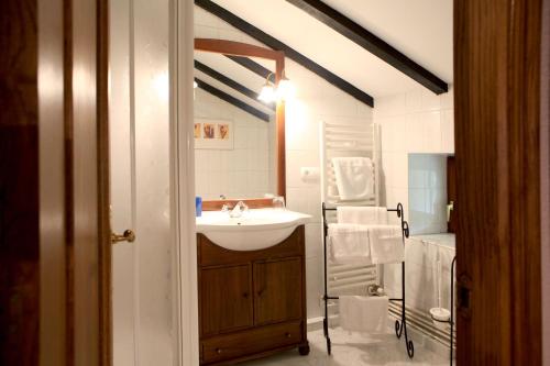 uma casa de banho branca com um lavatório e uma escada em Casa Rural Malkornea em Maya del Baztán