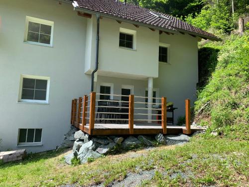 a house with a wooden deck in front of it at Ferienwohnung Unsere Mühle in Kirchbach