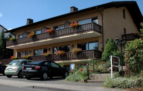 バート・ヴィルドゥンゲンにあるPension Gimpelの建物の前に車が駐車されている
