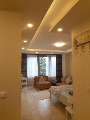 a bedroom with a bed and a living room with a couch at Apartman Markos in Vrnjačka Banja