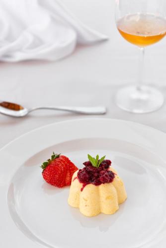 a white plate with two strawberries on a table at Sporting Hotel San Felice in Illasi