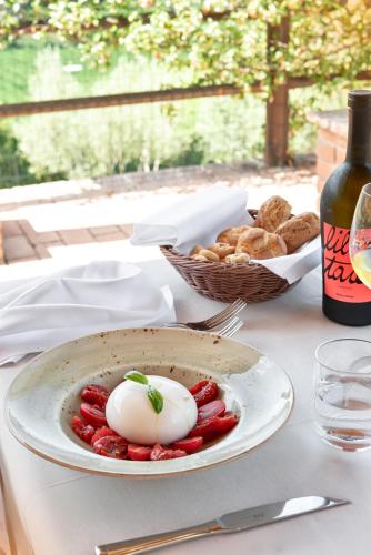a table with a plate of food and a bottle of wine at Sporting Hotel San Felice in Illasi
